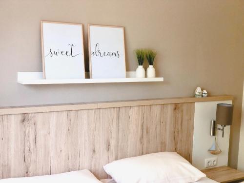 a shelf above a bed with two pictures on it at PerlePlau in Plau am See