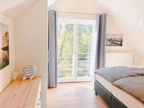 a bedroom with a bed and a large window at PerlePlau in Plau am See