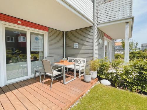 a wooden deck with a table and chairs on it at PerlePlau in Plau am See