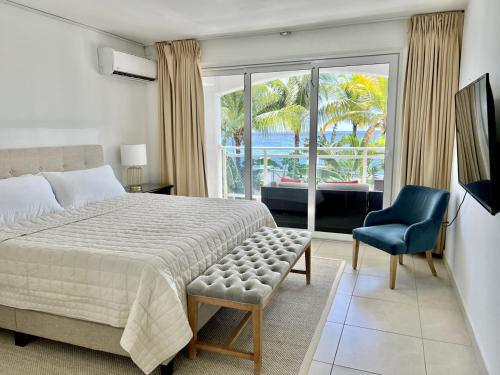 um quarto com uma cama, uma cadeira e uma janela em Maho Beach Hideaway Lux 1BR next to The Morgan Resort em Maho Reef