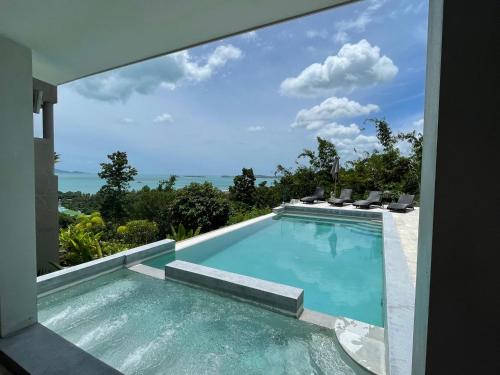 a swimming pool with a view of the ocean from a house at VILLA ARGANDA Infinity Pool Luxury Sea View in Bophut