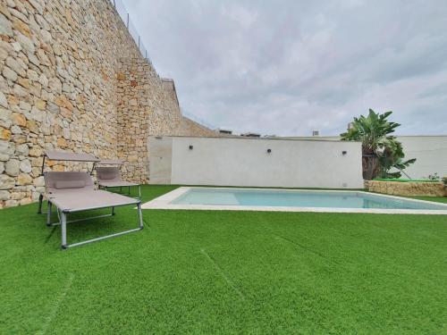 a patio with a chair and a swimming pool at Chalet con piscina privada in Valencia