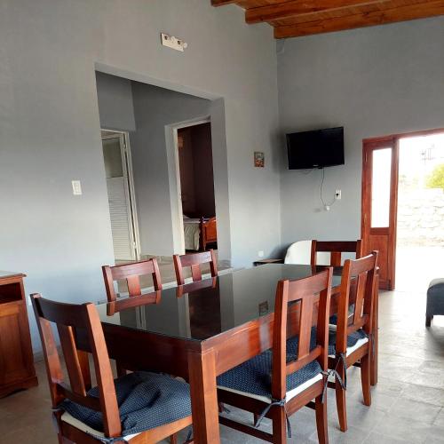 a dining room with a glass table and chairs at El Pedregal Cabaña rural 2 dorm Hasta 6 personas in Cafayate