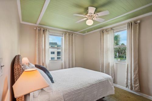 um quarto com uma cama e uma ventoinha de tecto em Friendly Native 507 em St. Pete Beach