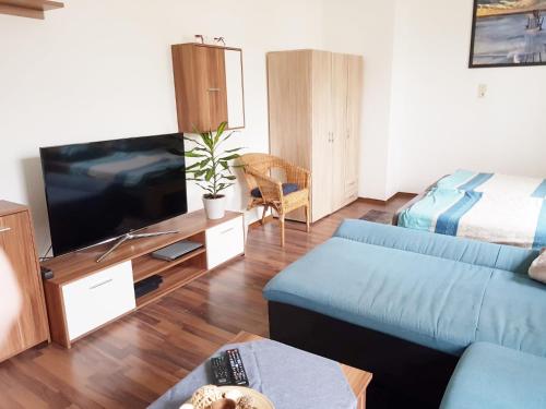 a living room with a blue couch and a tv at Haus Ajax in Anklam