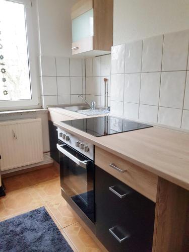 a kitchen with a black stove and a sink at Haus Ajax in Anklam