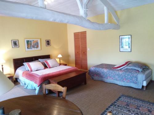 - une chambre avec 2 lits et une table dans l'établissement Les Hôtes du Paradis, à Forges