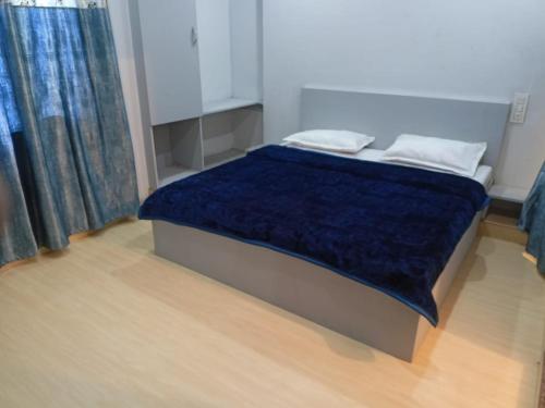 a bed with a blue comforter in a room at Hotel Shubham in Jalandhar