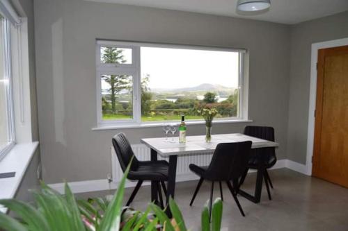 uma sala de jantar com uma mesa e cadeiras e uma janela em Twin Lake View - Bungalow in Pontoon em Foxford