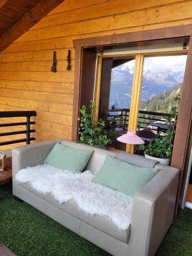 a couch on a porch with a view of a mountain at Highest terrace Verbier center. Top comfort & view in Verbier