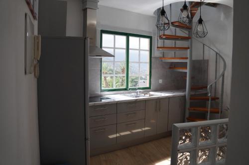una cocina con escalera, lavabo y ventana en Casa Teide, en La Orotava