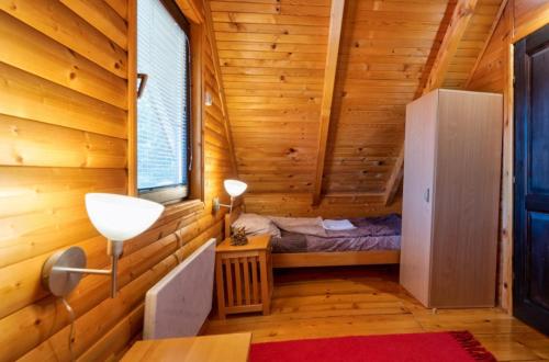 a room with a bed in a wooden cabin at Zlatibor Brvnare Zakos in Zlatibor