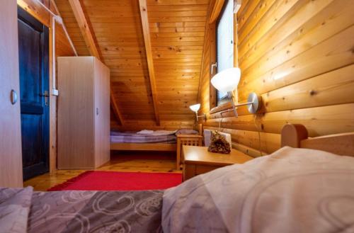 a bedroom with a bed in a wooden cabin at Zlatibor Brvnare Zakos in Zlatibor