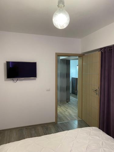 um quarto com uma televisão de ecrã plano na parede em CassaTa-Two-Vaslui em Vaslui