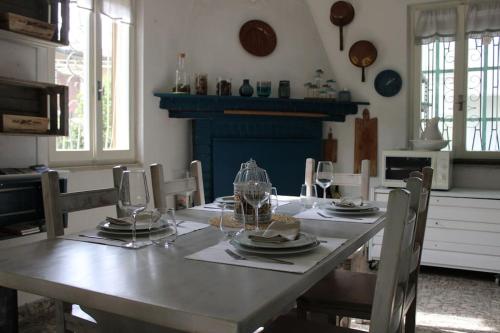 a dining room table with plates and glasses on it at Casa Sivori sul lago di Garda con ampio giardino in Desenzano del Garda