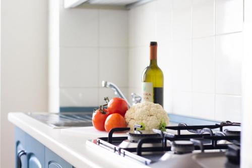a kitchen counter with a bottle of wine and vegetables at Happy Home in Saronno