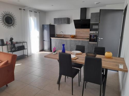 une cuisine et une salle à manger avec une table et des chaises en bois dans l'établissement Gite les edelweiss Fleurs des Pyrénées, à Argelès-Gazost
