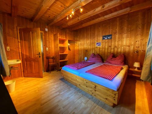 um quarto com uma cama num quarto de madeira em Ferienhaus Falbeson em Neustift im Stubaital