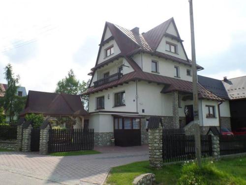 une grande maison blanche avec un toit marron dans l'établissement Pokoje u Mariana, à Groń