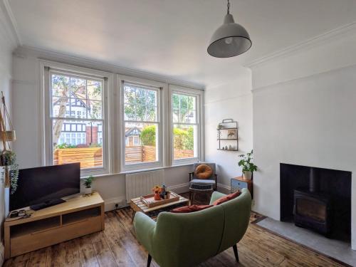 a living room with a couch and a tv at *Unique Brighton Apartment & Garden, near Beach* in Brighton & Hove