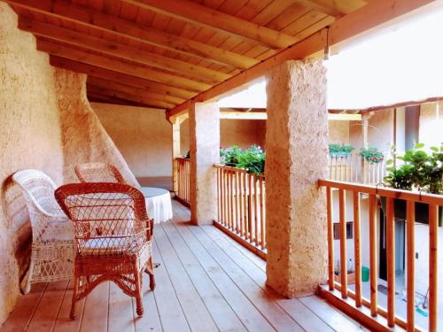 - une terrasse couverte avec des chaises en osier et une table dans l'établissement Casa Las Eras, à San Martín del Camino