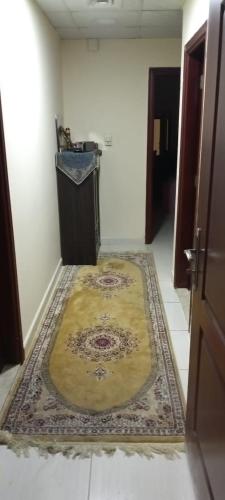a hallway with a rug on the floor in a room at بناية يا هلا in Ajman 