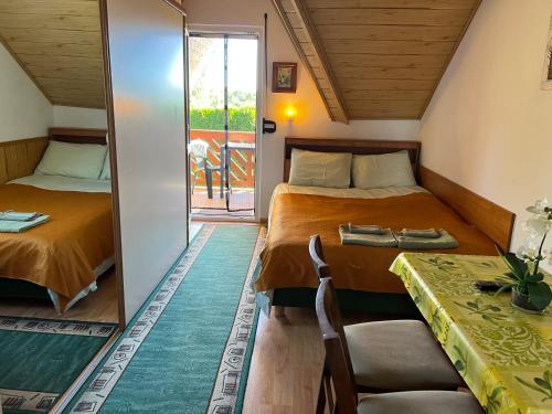 Cette petite chambre comprend deux lits et une table. dans l'établissement DW Villa Miami, à Łeba