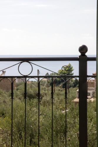 a fence with a view of a field of grass at Mani Cosy View Maisonette in Riglia