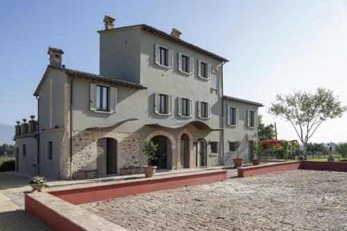 a large house with a stone driveway in front of it at SeiPetali in Cannara