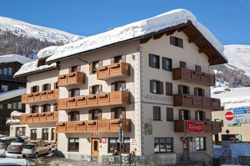 a building with snow on top of it at Hotel San Rocco in Livigno