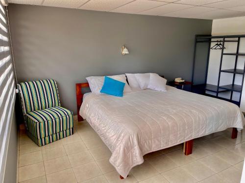 a bedroom with a bed and a chair at El Balcon de los Reyes in Ibarra