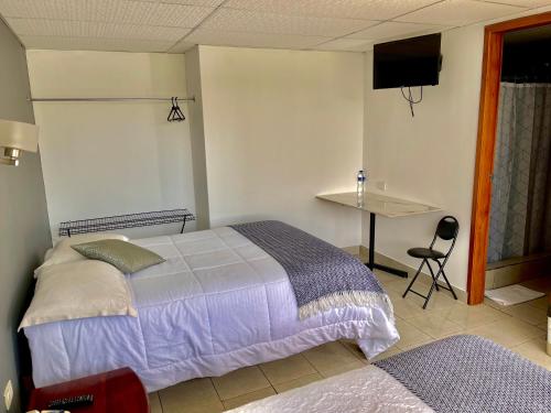 a bedroom with a bed and a table and a desk at El Balcon de los Reyes in Ibarra