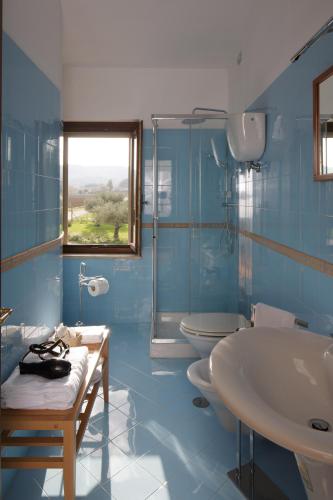 a blue bathroom with two toilets and a sink at SeiPetali in Cannara