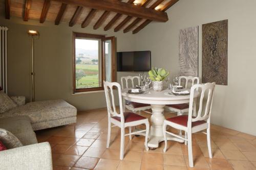 sala de estar con mesa, sillas y sofá en SeiPetali en Cannara