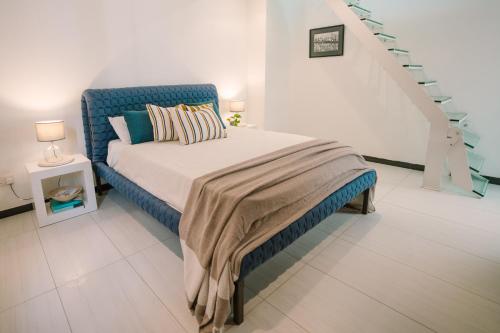 a bedroom with a bed with a blue headboard and stairs at Valletta Dream Penthouse in Valletta