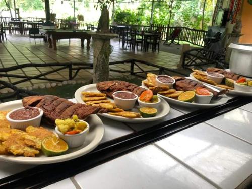 un buffet con platos de comida en una mesa en Casona Tica Linda en Sarapiquí