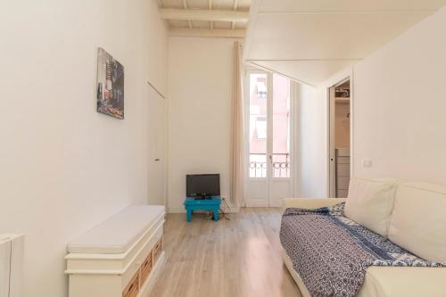 uma sala de estar branca com uma cama e uma televisão em [New flat] Crocetta 2 em Milão
