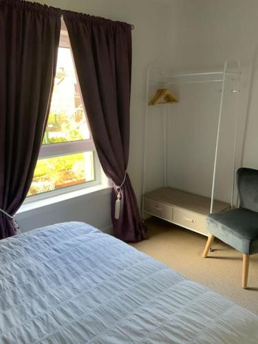 Home from home, 3 bedroom house in Hawick في هاويك: غرفة نوم بسرير ونافذة وكرسي