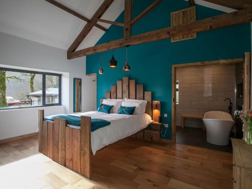 a bedroom with a large bed and a bath tub at The Pendre Longbarn in Pentre-briwnant