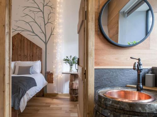 a bathroom with a sink and a bed and a mirror at The Pendre Longbarn in Pentre-briwnant