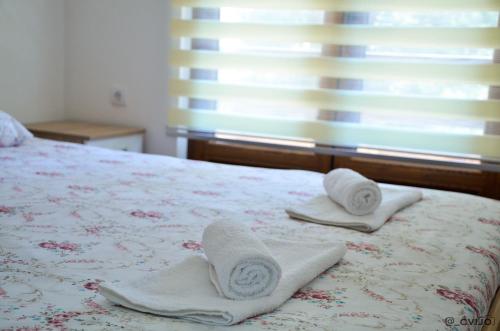 a bedroom with a bed with towels on it at Apartman Sofija in Kaludjerske Bare