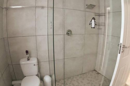 a shower stall with a toilet in a bathroom at Apt on Beach front, Modern 2BR Solar, 50m to beach in Strandfontein