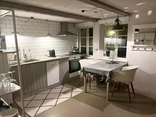 a kitchen with a table and some chairs and a table and a kitchen at Studio Råå in Helsingborg