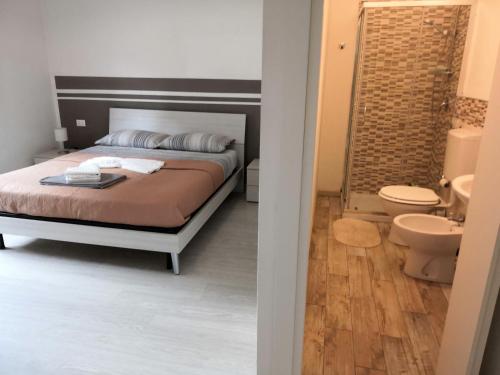 een slaapkamer met een bed en een badkamer met een toilet bij B&B Matteotti 23 in Bologna