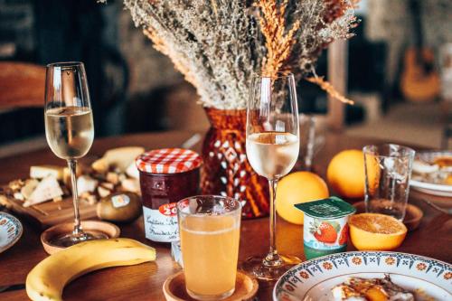 een tafel met twee glazen champagne en een bord eten bij Le Refuge de Maïly in Beauraing