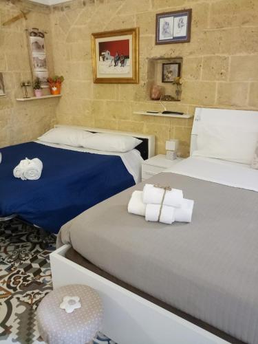 a bedroom with two beds with towels on them at Le camelie in Altamura