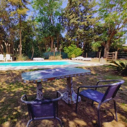 a table and two chairs in front of a pool at Posada Don Salvador in San Antonio de Areco