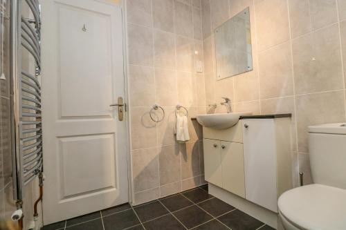 a bathroom with a white toilet and a sink at Valley Lodge 5 in Callington