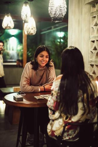two women sitting at a table in a restaurant at Black Llama Hostel Miraflores in Lima