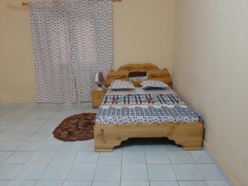 a bedroom with a wooden bed in a room at Villa Chambre A climatisée douche Cuisine salon in Bamako